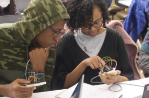 Two students looking at a wearable device