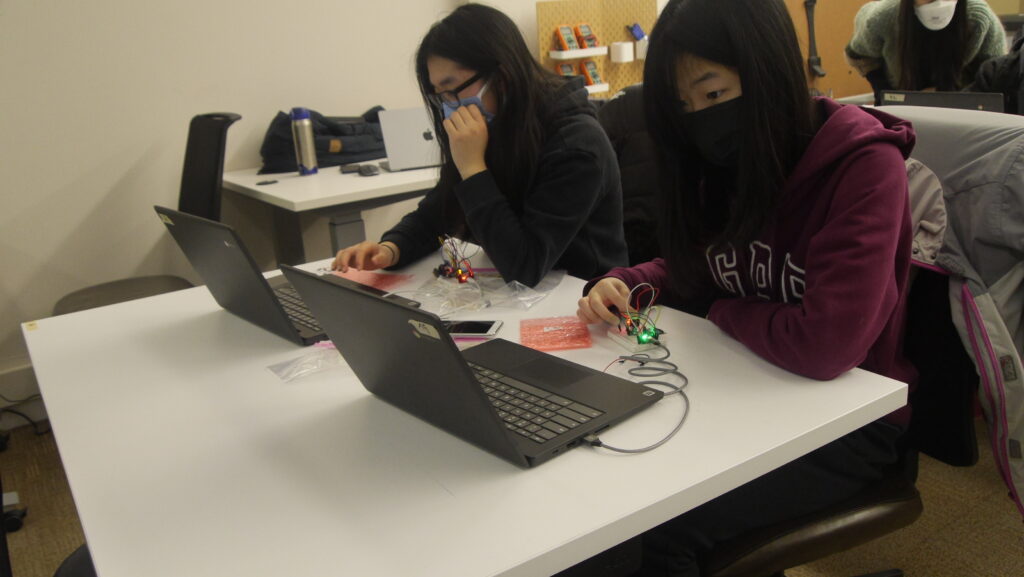 Two students work on their wearable devices