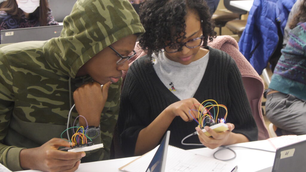 Two students looking at a wearable device