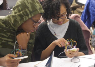 Two students looking at a wearable device